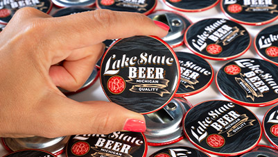Hand Holding a Custom Bottle Opener Printed for Lake State Beer