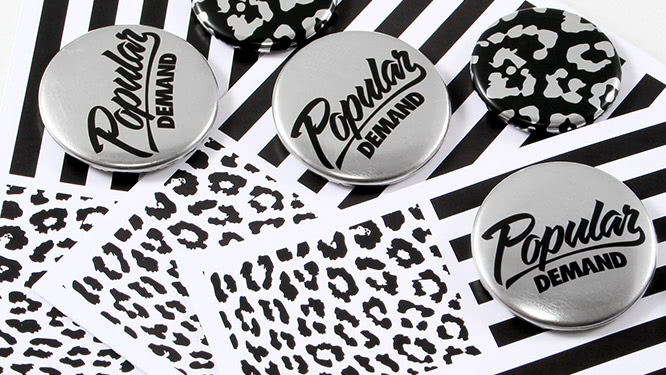 Custom button packs featuring two metallic finish buttons for the brand Popular Demand