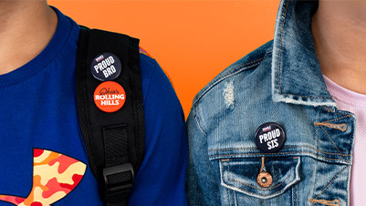Two Students Wearing 1.25" Buttons Reading "Proud Bro" and "Proud Sis"