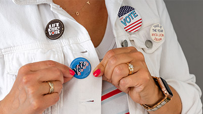 Woman Pinning Campaign Buttons to Her Jacket