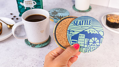 Hand holding custom souvenir coasters for Seattle Washington