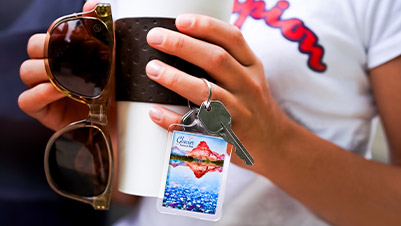 Hand holding Glacier National Park souvenir keychain with keys attached