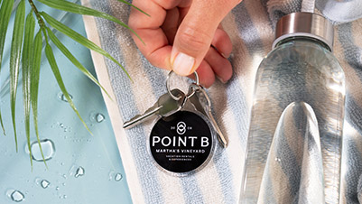 Hand holding a round key ring for Point B Marthas Vineyard Vacation Rentals