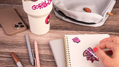 Hands Applying Kiss Cut Glitter Stickers to a Notebook