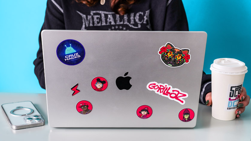 Custom Glitter Stickers applied to a laptop and coffee cup